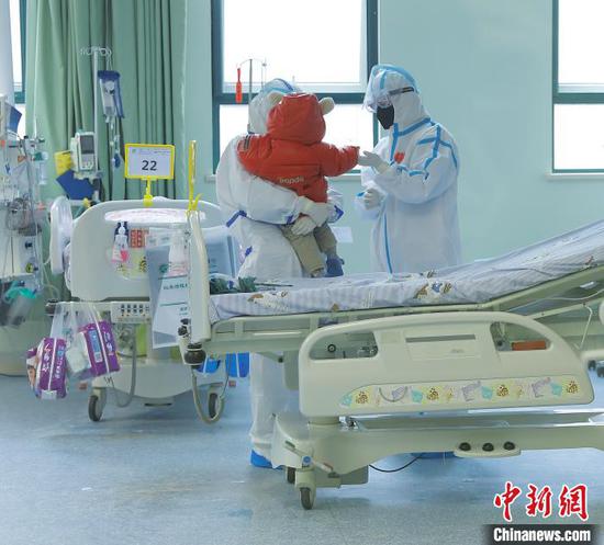 14-month-old says goodbye with doctors after recovery at the Wuhan Children's Hospital, Hubei Province, Feb. 13， 2020. (Photo provided to China News Service)