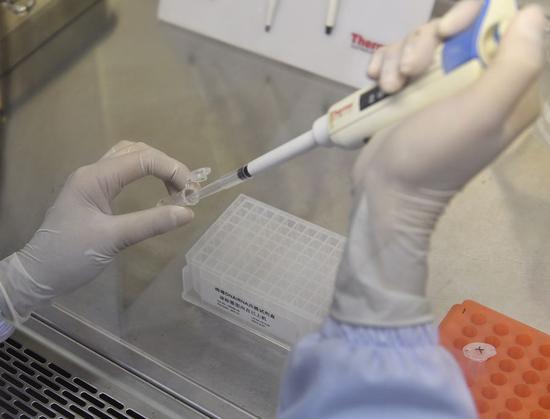 A staff member checks the quality of nucleic acid extraction kits at Chengdu Bio-Base Technologies Co., Ltd. in Chengdu, southwest China's Sichuan, Feb. 10, 2020. (Xinhua/Liu Kun)