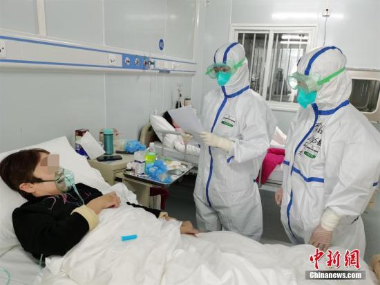 Medical staff visit a patient with confirmed novel coronavirus (COVID-19) infection. (China News Service)