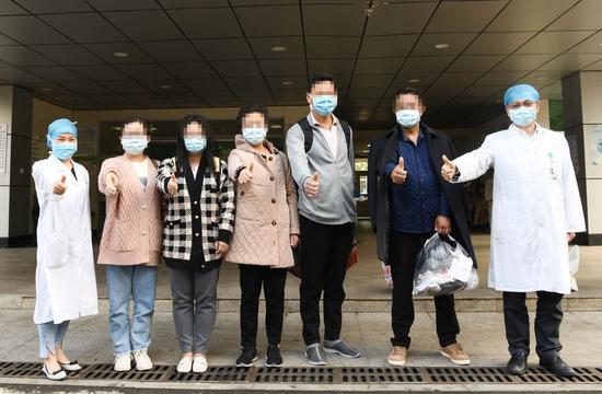 The cured patients pose for a photo with medical staff at Hainan General Hospital in Haikou, south China's Hainan Province, Feb. 12, 2020. (Xinhua/Yang Guanyu)
