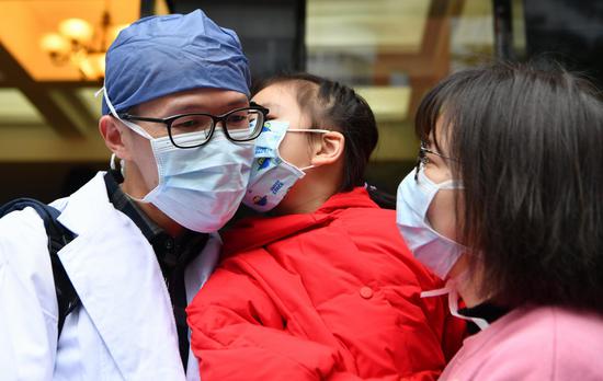 Medical team member Lin Kai (L) bids farewell to his family before leaving for Wuhan of central China's Hubei Province at the Affiliated Union Hospital of Fujian Medical University in Fuzhou, southeast China's Fujian Province, Feb. 13, 2020. (Xinhua/Wei Peiquan)