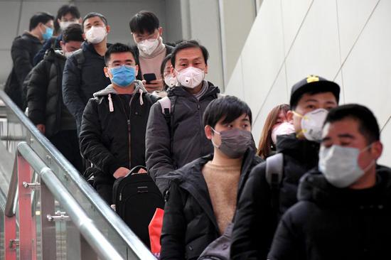 Passengers wearing masks take an escalator at Zhengzhou East Railway Station in Zhengzhou, central China's Henan Province, Feb. 1, 2020. (Xinhua/Li An)
