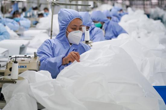 Workers make general protective suits at Hongdou Industrial Co., Ltd. in Wuxi, east China's Jiangsu Province, Feb. 8, 2020. (Xinhua/Li Bo)