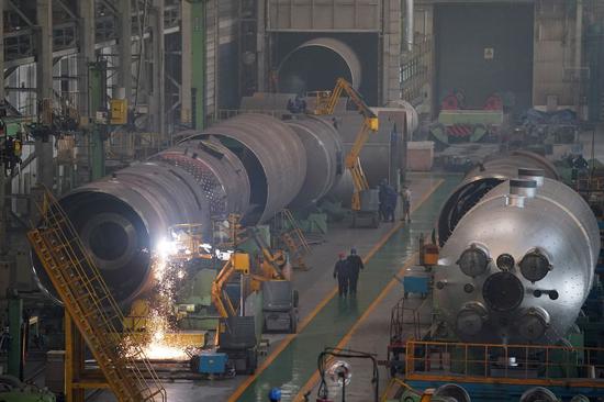 People work in a workshop of Harbin Boiler Company Limited in Harbin, northeast China's Heilongjiang Province, Feb. 10, 2020. (Xinhua/Wang Jianwei)