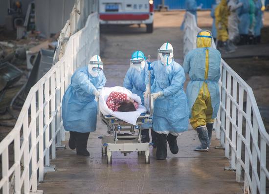 Medical workers help the first batch of patients infected with the novel coronavirus move into their isolation wards at Huoshenshan (Fire God Mountain) Hospital in Wuhan, central China's Hubei Province, Feb. 4, 2020. (Xinhua/Xiao Yijiu)