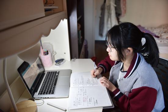 A student takes online courses at home in Beijing, Feb. 17, 2020. (Photo by Chen Zhonghao/Xinhua)