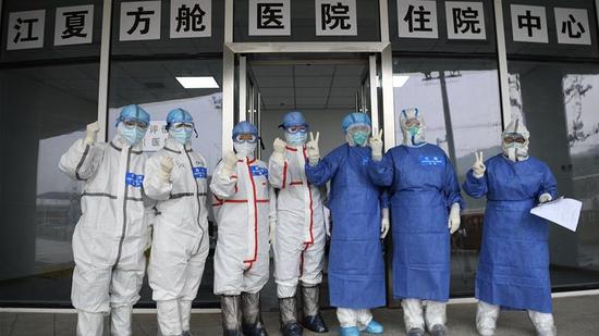 Medical workers pose for a group photo at Jiangxia temporary hospital in Wuhan, capital city of Central China's Hubei province, Feb 14, 2020. [Photo/Xinhua]