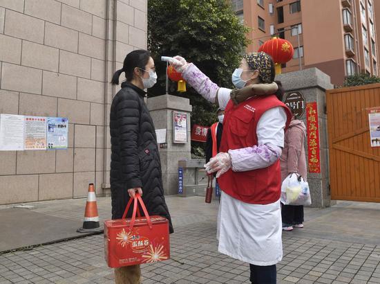 A community medical worker measures body temperature for a resident in Chengdu, capital of southwest China's Sichuan Province, Feb. 4, 2020. (Xinhua/Liu Kun)