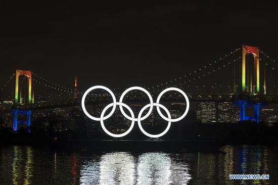 Olympic rings are illuminated during an event to mark six months before the opening of the Tokyo 2020 Olympic Games in Tokyo, Japan, on Jan. 24, 2020. (Photo by Christopher Jue/Xinhua)