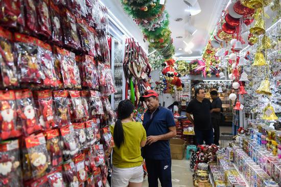 A foreign businessman selects Christmas commodities at the Yiwu International Trade City in Yiwu, east China's Zhejiang Province, June 26, 2019. (Xinhua/Huang Zongzhi)