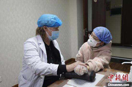 John Cary takes pulse for a visitor at the Hospital of TCM and Hui Nationality Medicine affiliated to Ningxia Medical University. (Photo: China News Service/Li Peishan)