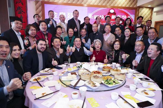 Chinese Consul General in New York Huang Ping (5th L, front), together with John Chan (4th L, front), president of Brooklyn-based Asian American Community Empowerment, chant slogans to support China's battle against coronavirus during an event held at the Golden Imperial Palace, a major restaurant in New York City's borough of Brooklyn, the United States, Feb. 16, 2020. (Xinhua/Wang Ying)