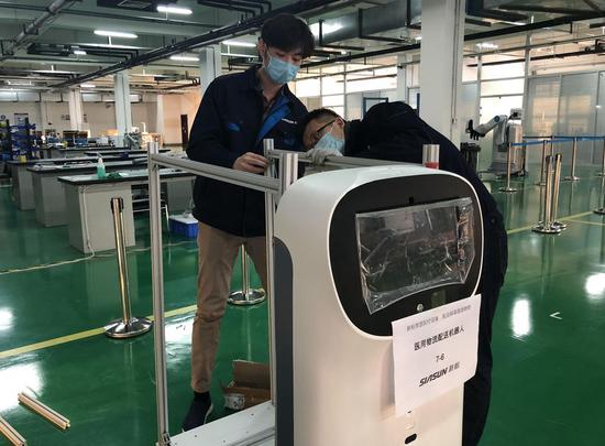 Engineers adjust a medical delivery robot developed by robot manufacturer SIASUN Robot & Automation Co., Ltd. in Shenyang, northeast China's Liaoning Province, Feb. 3, 2020. (Photo by Yang Qing/Xinhua)