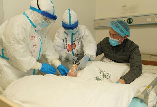 Medical workers inject medicine for Li Zuofan(R) at an intensive care ward of the novel coronavirus infection cases at Tongji Hospital in Wuhan, central China's Hubei Province, Feb. 18, 2020. (Xinhua/Wang Yuguo)