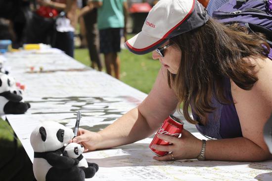 A woman signs her name to support Wuhan in Canberra, Australia, Feb. 22, 2020. (Photo by Liu Changchang/Xinhua)