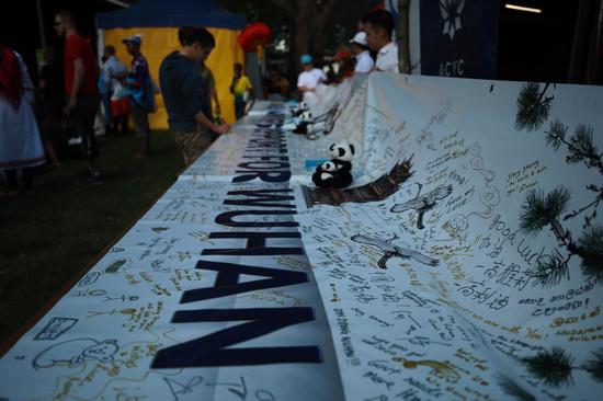 Local people sign their names to express support to China's Wuhan at the 2020 National Multicultural Festival in Canberra, Australia, Feb. 22, 2020. (Photo by Chu Chen/Xinhua)