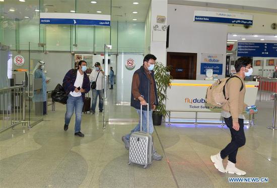 Kuwaiti nationals evacuated from Iran walk out of a terminal at Kuwait International Airport in Farwaniya Governorate, Kuwait, Feb. 22, 2020. Kuwait received the arrival of the first flight from Iran with Kuwaiti nationals on Saturday, as part of the country's evacuation plan after the COVID-19 outbreak in Iran. (Photo by Asad/Xinhua)