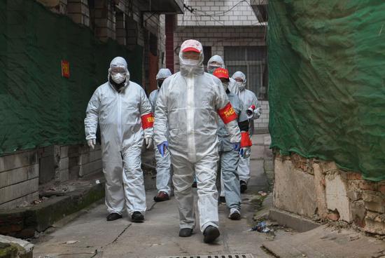 Volunteers visit a community in Jiang'an District of Wuhan, central China's Hubei Province, Feb. 9, 2020. (Xinhua/Cheng Min)