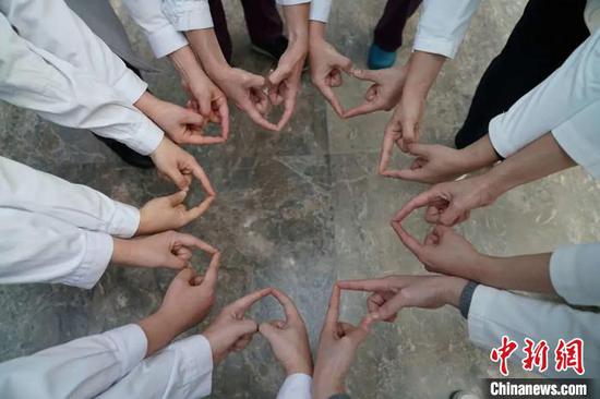 Medical staff bless Xiao Tangyuan by making a circle with heart-shaped gestures. (Photo/China News Service)