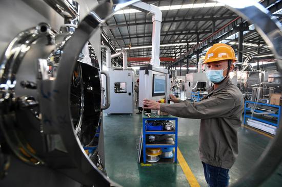 An employee works on a production line to produce dry granulators, which will be supplied to drug manufacturers in Shanghai and other cities to help combat the coronavirus, at Wanshen Pharmaceutical Machinery Co., Ltd. in Yichun, east China's Jiangxi Province, Feb. 24, 2020. (Xinhua/Zhou Mi)