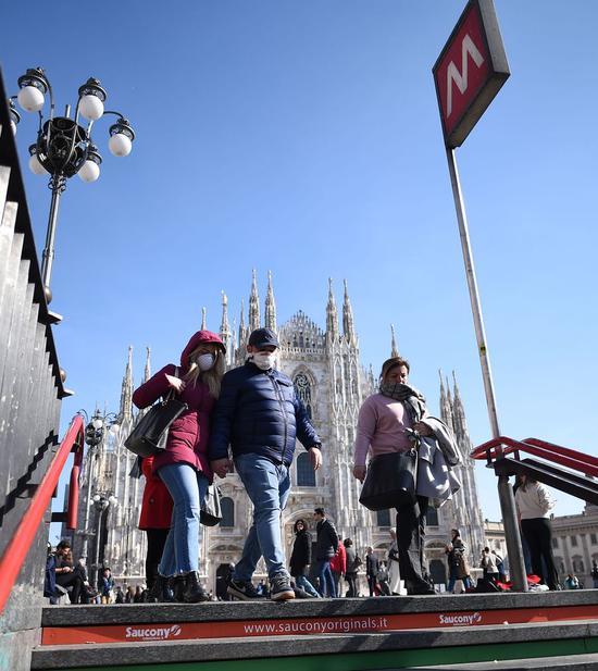 People wearing masks walk into a subway station in Milan, Italy, on Feb. 24, 2020.(Photo by Daniele Mascolo/Xinhua)