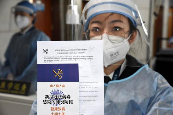 A customs officer shows the health declaration form for passengers at Qingdao Liuting International Airport in Qingdao, east China's Shandong Province, Feb. 25, 2020. (Xinhua/Li Ziheng)