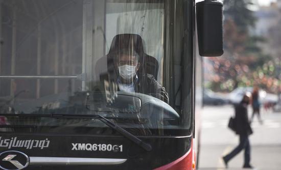 A bus driver wears a face mask in Tehran, Iran, on Feb. 26, 2020. (Photo by Ahmad Halabisaz/Xinhua)