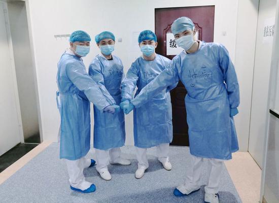 The four male nurses Tang Qiaojie, Liu Ming, Zhang Yong and Zhang Yingzhen (L to R), from a special team taking care of children infected with novel coronavirus pneumonia, cheer themselves up in Wuhan Children's Hospital in Wuhan, central China's Hubei Province, Feb. 26, 2020. (Xinhua)