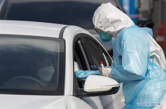 A medical worker of hospital of Yeungnam University makes health screening at a drive-through clinic in Daegu, South Korea, March 4, 2020.  (Photo by Lee Sang-ho/Xinhua)