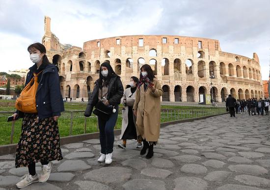 Tourists wearing face masks visit the Colosseo in Rome, Italy, on March 4, 2020. (Photo by Alberto Lingria/Xinhua)