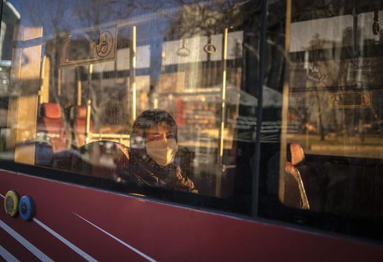 A woman wearing a face mask is seen on a bus amid the novel coronavirus outbreak in Tehran, Iran, on March 2, 2020. (Photo by Ahmad Halabisaz/Xinhua)