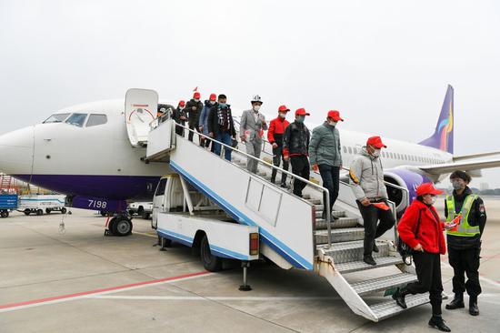 Migrant workers from Xinjiang Uygur Autonomous Region get off a chartered airplane at Sunan Shuofang International Airport in Wuxi, east China's Jiangsu Province, Feb. 26, 2020. (Xinhua/Li Bo)