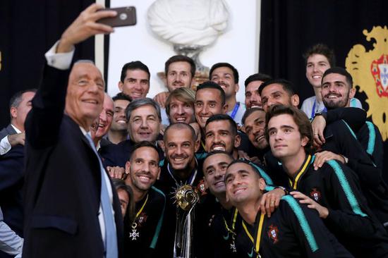Portuguese President Marcelo Rebelo de Sousa takes a selfie with the players and the trophy of Beach Soccer World Cup after he awarded Portugal's national beach soccer team at the Belem Palace in Lisbon, Portugal, on Dec. 3, 2019.(Photo by Pedro Fiuza/Xinhua)