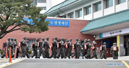Soldiers prepare to disinfect an apartment building where mass coronavirus infections occurred in Daegu, South Korea, March 9, 2020. South Korea confirmed 96 more cases of the COVID-19 on Monday, raising the total number of infections to 7,478. (NEWSIS/Handout via Xinhua)
