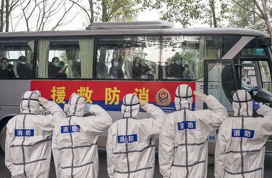 Staff members salute the cured coronavirus patients who have finished a 14-day quarantine for medical observation at a rehabilitation center in Wuhan on March 10, 2020. (Xinhua/Xiong Qi)