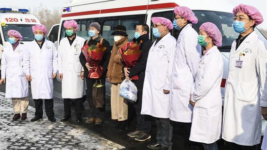 Three cured patients of COVID-19 pose for a group photo with medical staff at the No. 6 People's Hospital of Xinjiang Uygur Autonomous Region in Urumqi, northwest China's Xinjiang Uygur Autonomous Region, February 11, 2020. /Xinhua