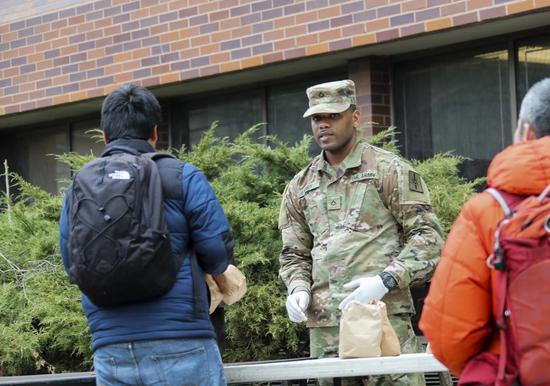 A member of National Guard distributes food to qualified residents near the one-mile-radius containment area in New Rochelle, New York State, the United States, on March 12, 2020. The U.S. state of New York set up a so-called 
