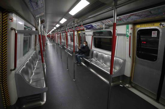 A passenger sits alone in a train carriage on the MTR's Hong Kong Island line. ([Photo by CALVIN NG/CHINA DAILY)