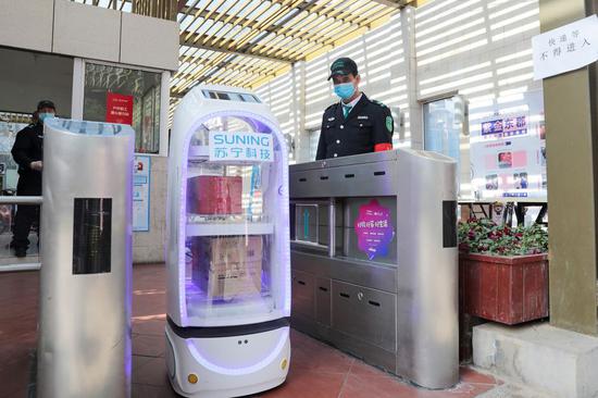 A robot of leading Chinese e-commerce company Suning.com delivers goods at a residential area in Nanjing, east China's Jiangsu Province, Feb. 10, 2020. (Xinhua)