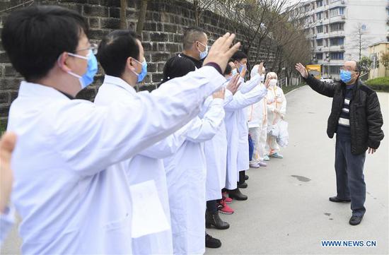 A recovered patient salutes to medical staff at the Chongqing Public Health Center in southwest China's Chongqing, March 15, 2020. The last patient diagnosed with the novel coronavirus disease (COVID-19) has been cured and discharged from the center, bringing the number of COVID-19 patients being treated in hospitals to zero in Chongqing. (Xinhua/Wang Quanchao)