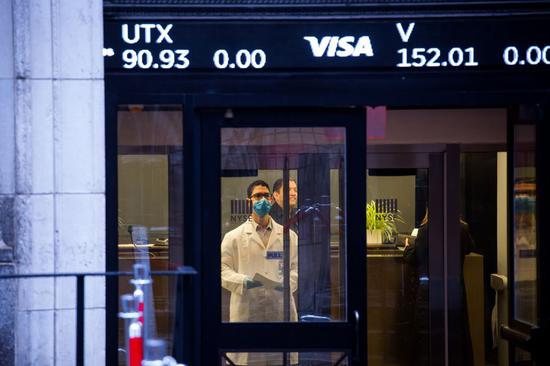 A medical worker waits to test the body temperature of entrants to the New York Stock Exchange (NYSE) in New York, the United States, March 17, 2020. (Xinhua/Michael Nagle)