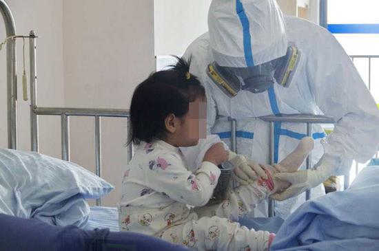 The undated file photo shows a medical worker taking care of a child diagnosed with novel coronavirus disease at Children's Hospital of Fudan University in east China's Shanghai. (Xinhua)