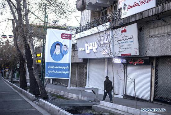 A man walks past an empty street in Tehran, Iran, on March 20, 2020. (Photo by Ahmad Halabisaz/Xinhua)