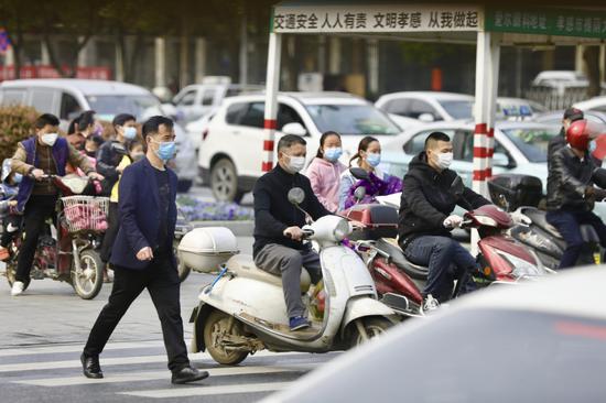 People wearing masks are seen on the street in Xiaogan, Central China's Hubei province, March 23, 2020. (Photo by Zhu Xingxin/chinadaily.com.cn)