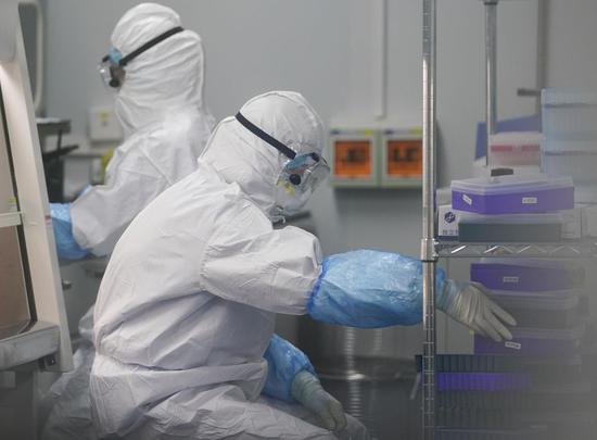 Staff members do nucleic acid testing work at a novel coronavirus detection lab in Wuhan, central China's Hubei Province, Feb. 22, 2020. (Xinhua/Cheng Min)