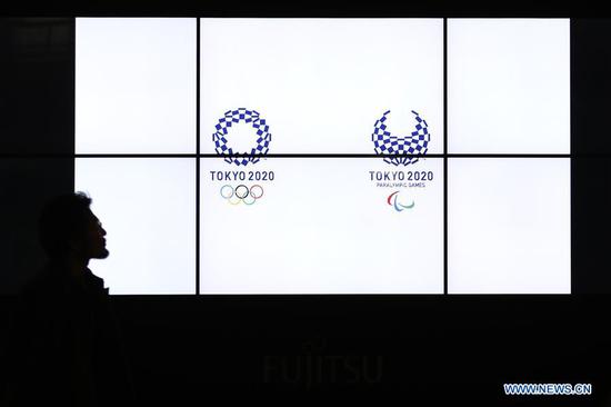 A pedestrian walks near a Tokyo 2020 Olympic Games countdown display in Shimbashi district of Tokyo, Japan, March 24, 2020. Japanese Prime Minister Shinzo Abe announced on Tuesday that Japan and the International Olympic Committee (IOC) have agreed to postpone the Tokyo Olympic and Paralympic Games by one year. (Xinhua/Du Xiaoyi)