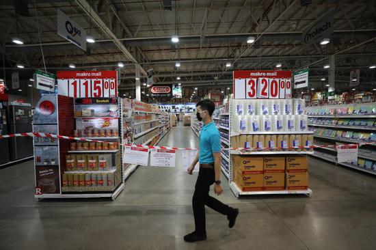 A worker walks past the closed area where the home appliance stock has been transferred to on-line sale to lower COVID-19 infection risk at a supermarket in Bangkok, Thailand, March 25, 2020. (Xinhua/Zhang Keren)