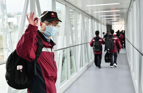 A medical expert waves goodbye before boarding a plane for Italy in Fuzhou, southeast China's Fujian Province, March 25, 2020. (Xinhua/Wei Peiquan)