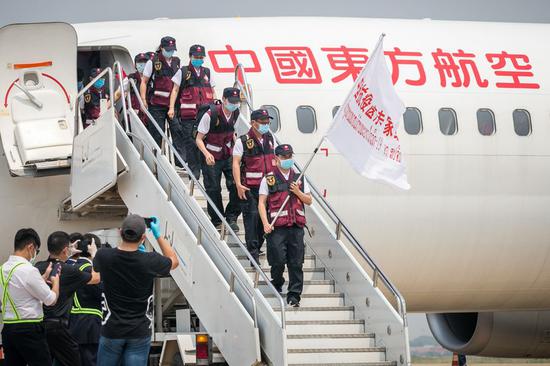 Chinese medical expert team walks down from a chartered plane at the Wattay International Airport in Vientiane, Laos, March 29, 2020. (Photo by Kaikeo Saiyasane/Xinhua)