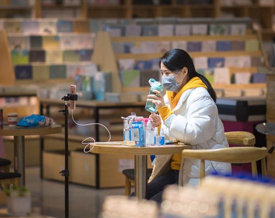 A salesclerk sells a water bottle in front of a phone camera via livestreaming at a shopping mall in Wuhan, Central China's Hubei province, on March 29, 2020. (Photo/Xinhua)